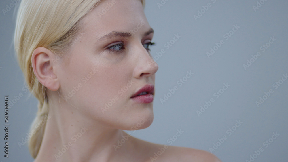 Nude portrait of stunning beauty blonde woman posing in the studio. Close-up of nice-looking girl touching her healthy shining skin face and smiling on camera. Nude portrait of stunning beauty blonde woman posing in the studio. Close-up of nice-looking girl touching her healthy shining skin face and smiling on camera.