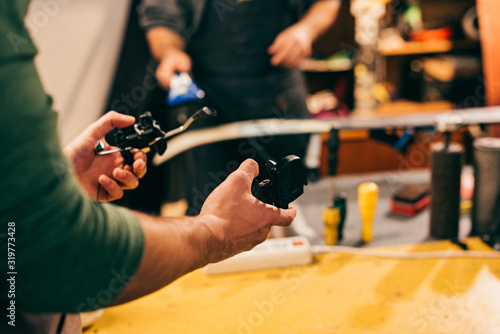 cropped view of worker holding grip vices in repair shop