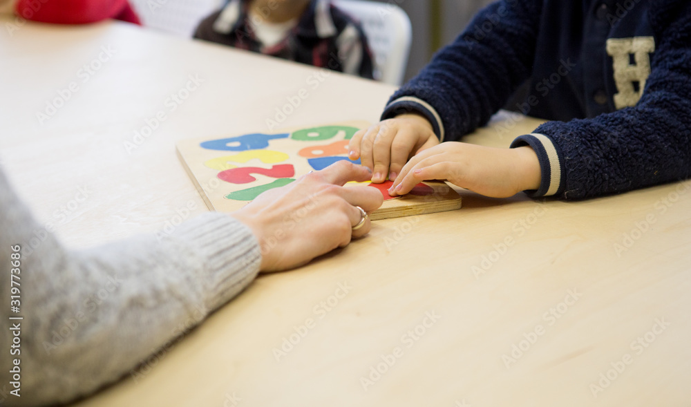 boy choosing number or numerals at the table with teacher