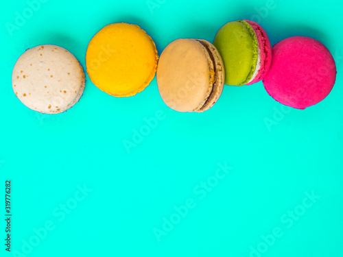 Colorful and tasty French Macarons on blue background.Top view.