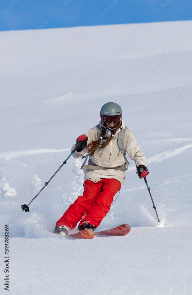 Girl On the Ski. a skier in a bright suit and outfit with long pigtails on
