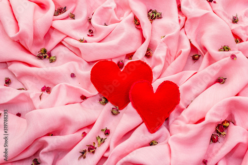 Valentines Day or Wedding card concept. Romantic design  red felt hearts  rose petals. Pink fabric background