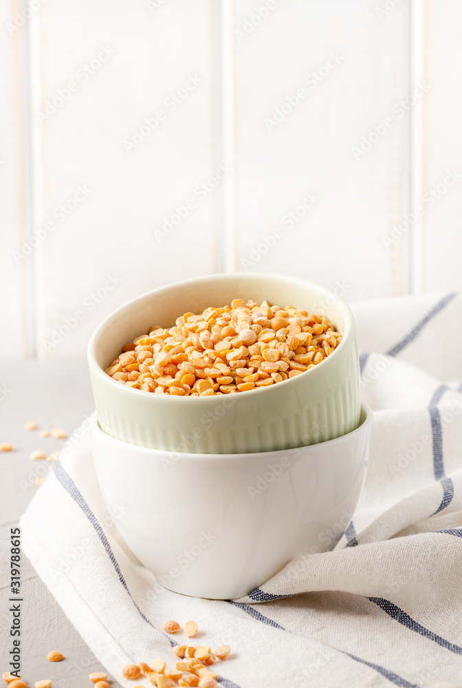 Dry uncooked peas in bowls on the kitchen table, copy space, light background. Dry uncooked peas in bowls on the kitchen table, copy space, light background.