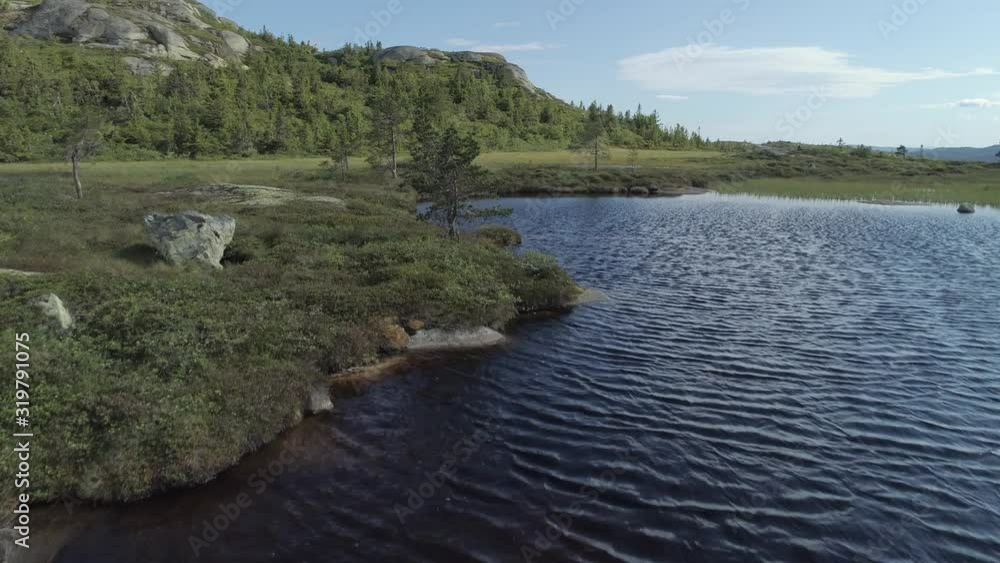 aerial of a lonley hiker at a scenic mountain lake revealing shot aerial of a lonley hiker at a scenic mountain lake revealing shot