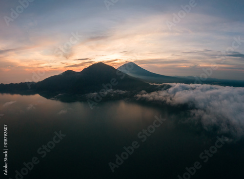 Aerial image of sunrise over Mount Agung with clouds and lake Danau Batur on Bali, Indonesia