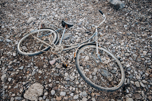 An old Bicycle abandoned on a shingle beach. Old bike with rust.