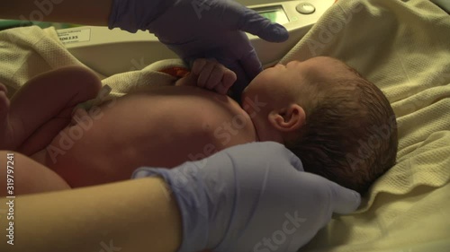 Newborn baby being weighed in Maternity unit in the hospital. She has just been born - on the scales.