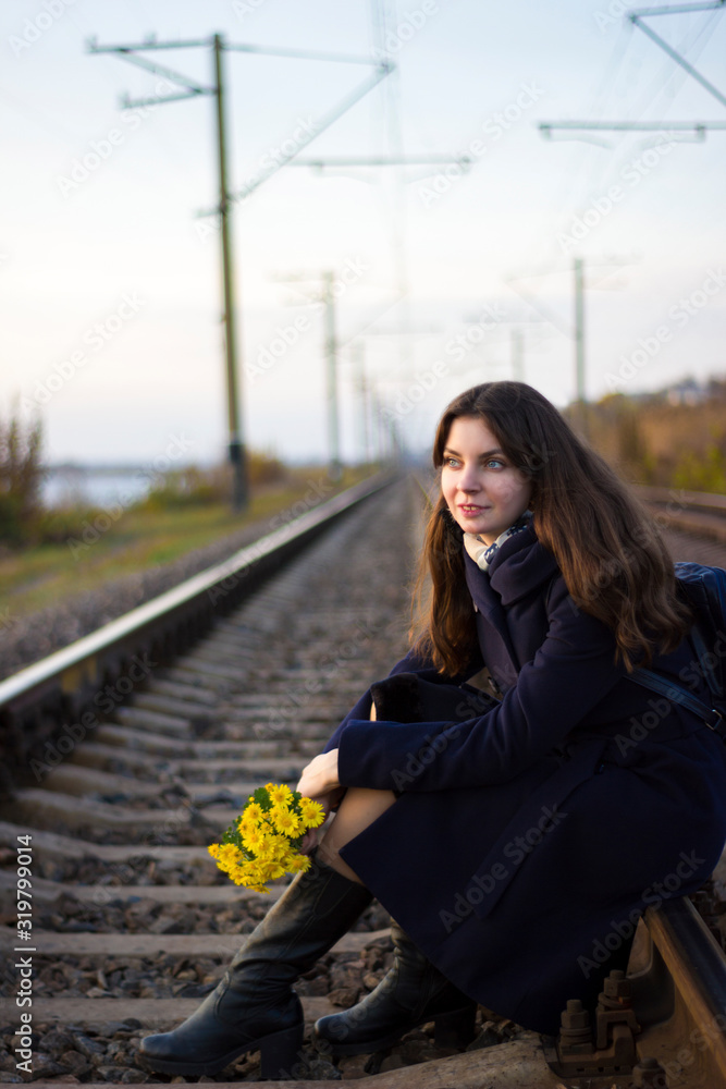 Girl walks on railway rails with flowers - travel, lifestyle, love