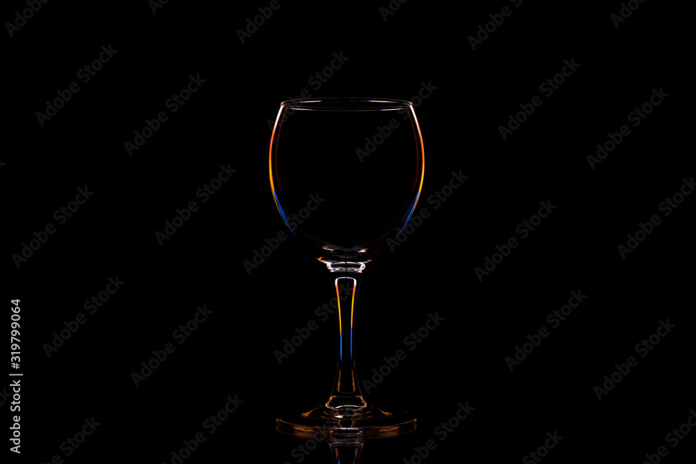 Glass with contour multicolored light on a black background with space for text.