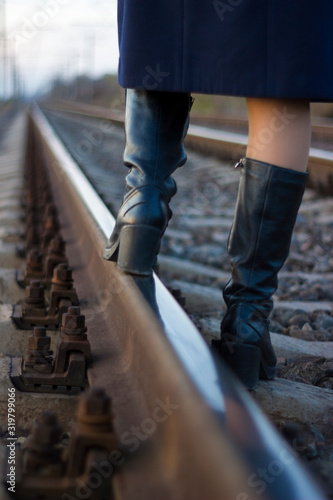 Girl walks on railway rails in a coat and boots - travel, lifestyle © alexey_m