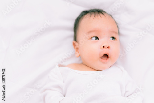 Smiling baby boy lying on a  white bed, Family morning at home,Children hygiene.