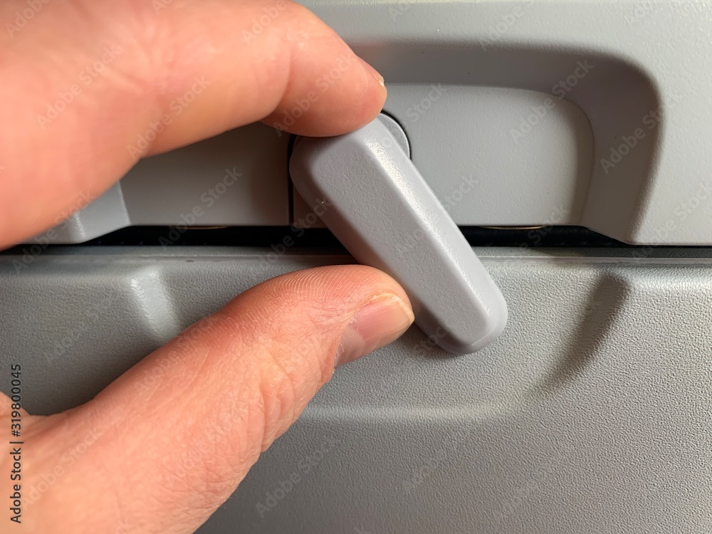 Foto de Generic airplane seat table tray latch in upright closed position do Stock Adobe Stock