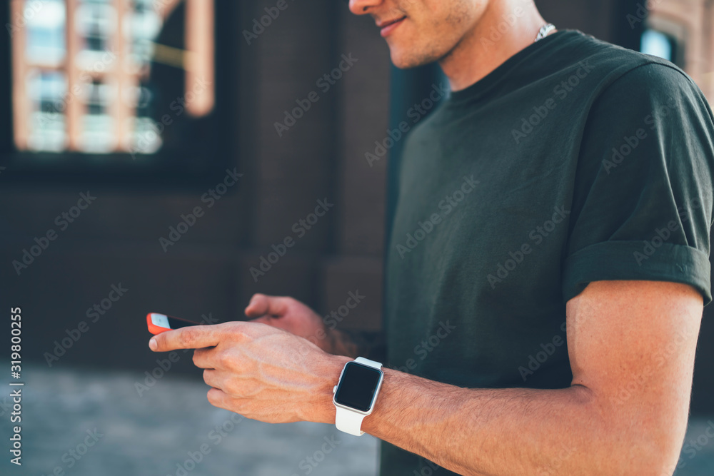 Cropped view of male blogger installing application on modern smartphone using 4G internet connection, millennial man holding new mobile phone in hands and chatting online on cellular device