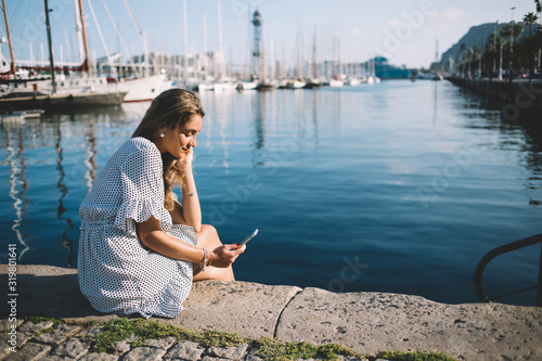 Calm lady using cellphone resting at waterside © BullRun