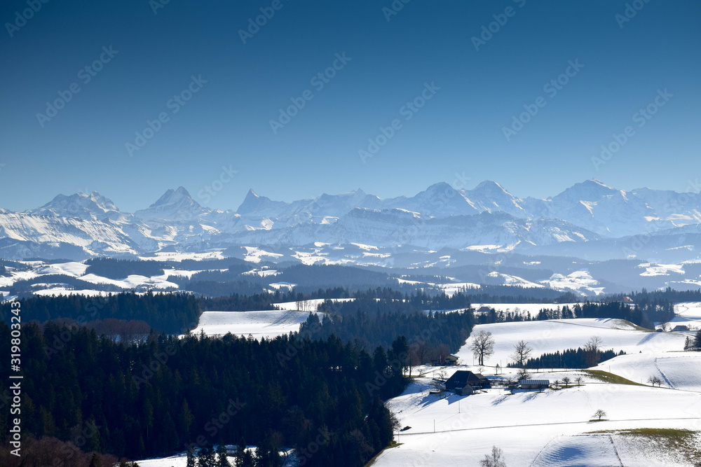 View over the emmental valley ant he alps on a sunny winter day. Canton Bern, Switzerland