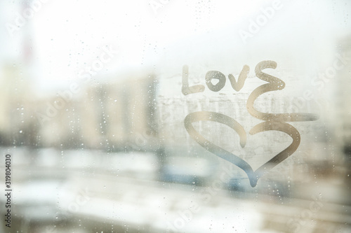 word love on the misted glass of window. 