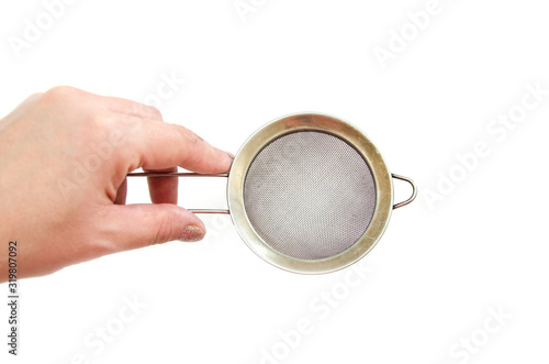 iron sieve in hand isolated on a white background. photo