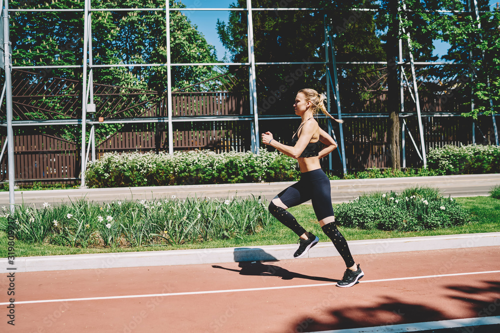 Obraz premium Strong young woman running on track in street
