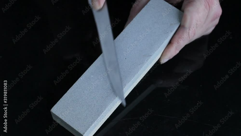 knife sharpening Whetstone on background of black boards. knife sharpening Whetstone on background of black boards.