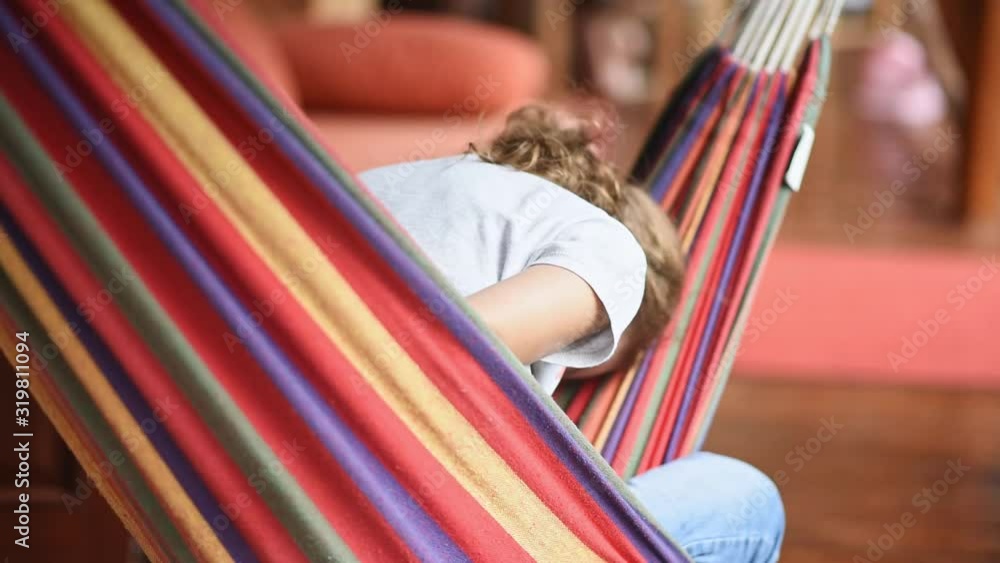 Depressed girl is swinging on a hammock. Colorful image. Teens problems. Close up
