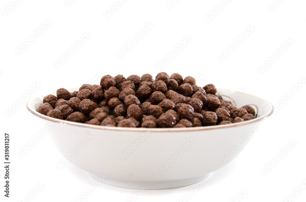 dry breakfast in a plate on a white background. Chocolate balls. dry breakfast in a plate on a white background. Chocolate balls.