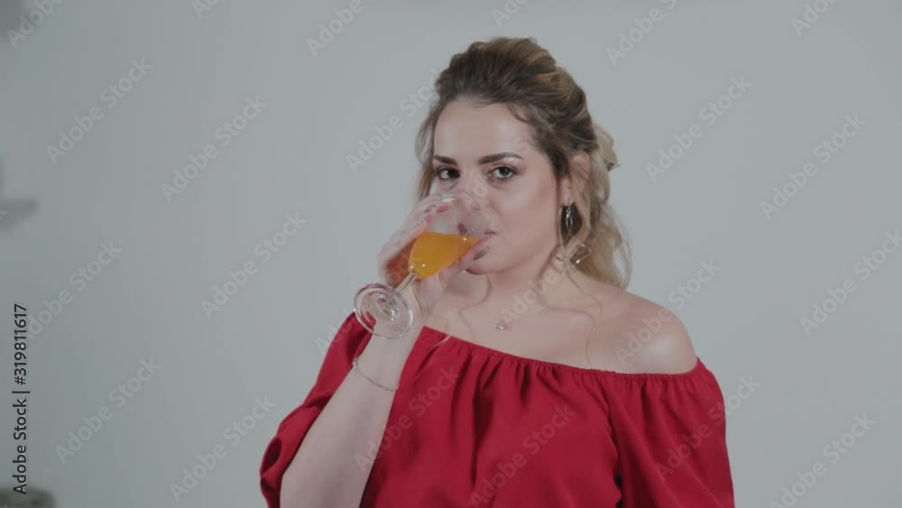 Beautiful young woman with a glass of juice in the kitchen. Beautiful young woman with a glass of juice in the kitchen.