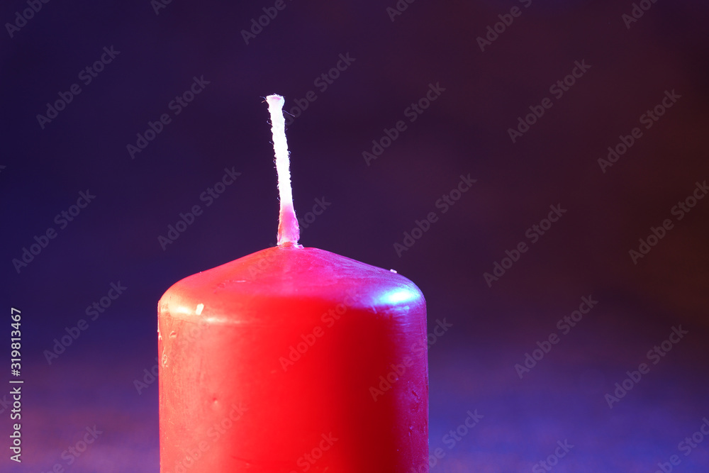 Red candle with smoke and flame photographed in the studio with color foils before the flashes Red candle with smoke and flame photographed in the studio with color foils before the flashes