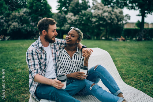 Multiracial  couple sitting on sunbed in garden © BullRun