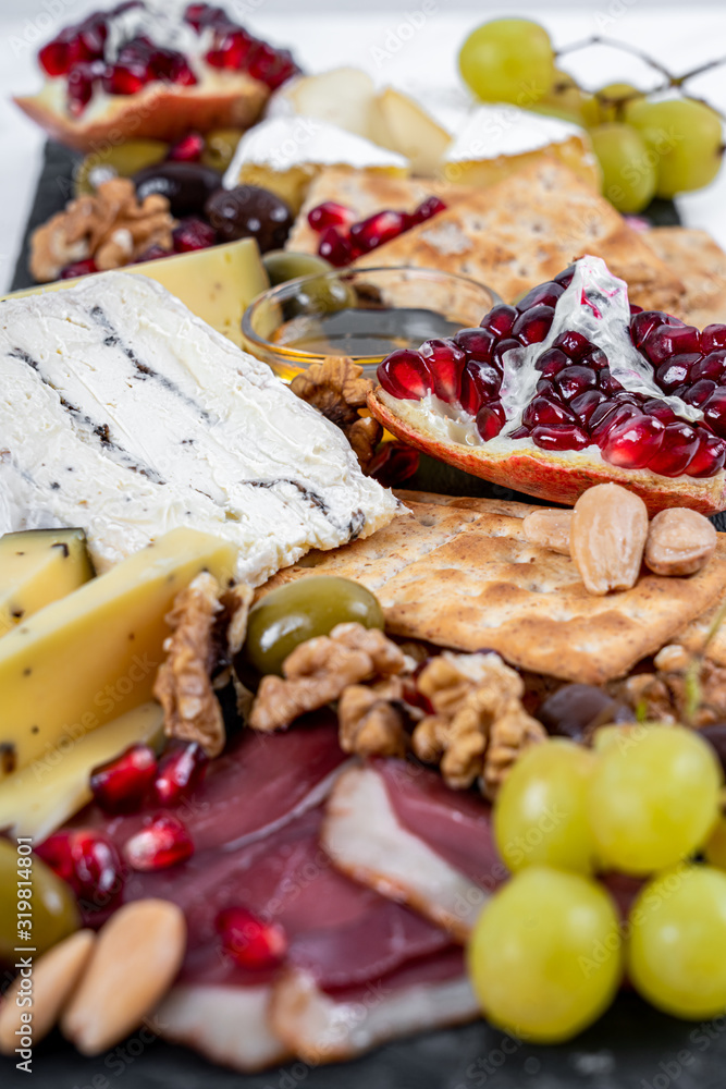 Food Platter With Truffle Cheese, Duck Breast, Brie Cheese, Pecan Nuts, Pomegranate Seeds, Grapes, Almonds, Honey, Olives and Crackers