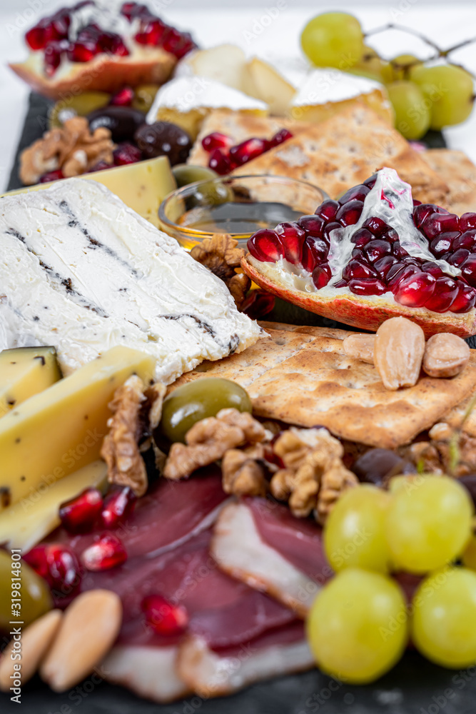 Food Platter With Truffle Cheese, Duck Breast, Brie Cheese, Pecan Nuts, Pomegranate Seeds, Grapes, Almonds, Honey, Olives and Crackers Food Platter With Truffle Cheese, Duck Breast, Brie Cheese, Pecan Nuts, Pomegranate Seeds, Grapes, Almonds, Honey, Olives and Crackers