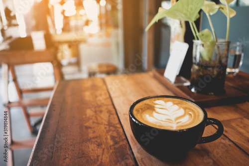 Latte cup on wooden table blur coffee shop background