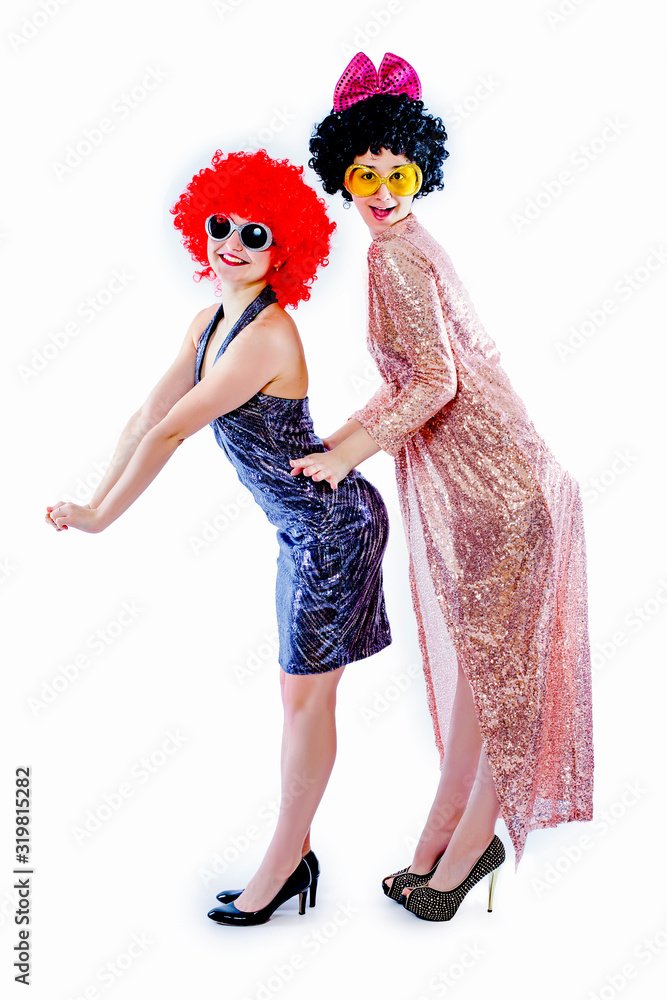 Attractive playful young women ready for carnival parties. Lifestyle and the concept of friendship: a group of two girl friends. Isolated on white Attractive playful young women ready for carnival parties. Lifestyle and the concept of friendship: a group of two girl friends. Isolated on white