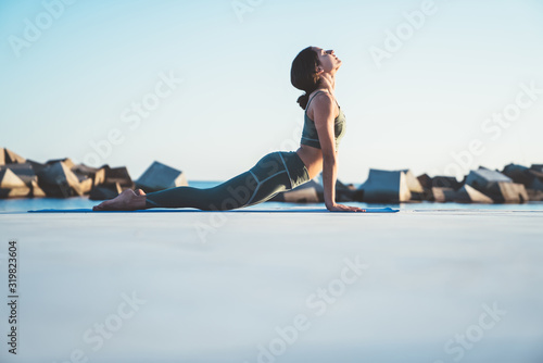 Shapely woman practicing yoga in cobra position