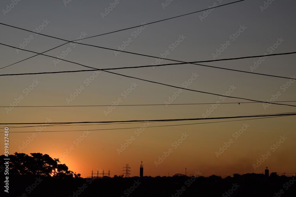 Por-do-Sol com silhueta de horizonte e fios elétricos