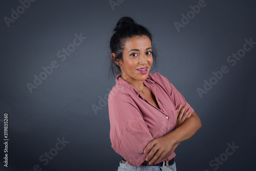 Image of cheerful pretty young caucasian businesswoman standing indoors with arms crossed. Looking and smiling at the camera. Confident girl.