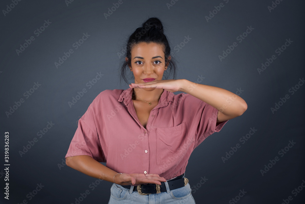 Young beautiful woman wearing winter sweater over isolated background gesturing with hands showing big and large size sign, measure symbol. Smiling looking at the camera. Measuring concept. Young beautiful woman wearing winter sweater over isolated background gesturing with hands showing big and large size sign, measure symbol. Smiling looking at the camera. Measuring concept.