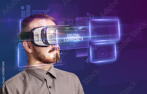 Businessman looking through Virtual Reality glasses with DIGITAL CURRENCY inscription, new technology concept