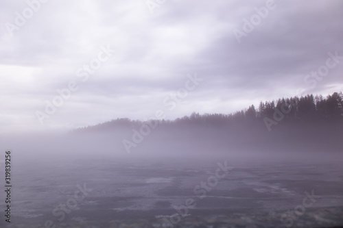 Zugefrorener Stausee in Nebel
