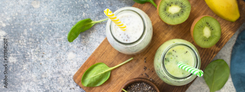 Healthy dieting and nutrition. Vegetarian concept. Blended Green detox vegetable smoothies with organic ingredients on a stone concrete tabletop. Top view flat lay background. Banner.