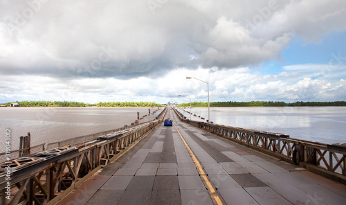 View of the pontoon bridge over the Demerara harbour bridge on a clear Sunny day before a thunderstorm, Guyana. World tourism, attractions, landscape. photo