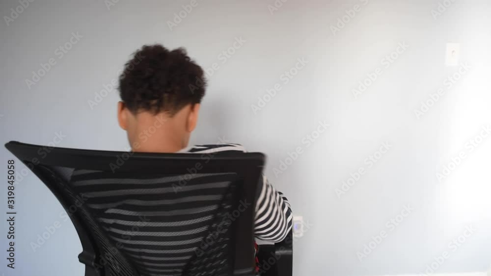 A young black african american pre teen showing different faces and turning around on his chairl. A cute playful boy, having fun, spinning his arm around. A young mixed male playing with by himself. A young black african american pre teen showing different faces and turning around on his chairl. A cute playful boy, having fun, spinning his arm around. A young mixed male playing with by himself.
