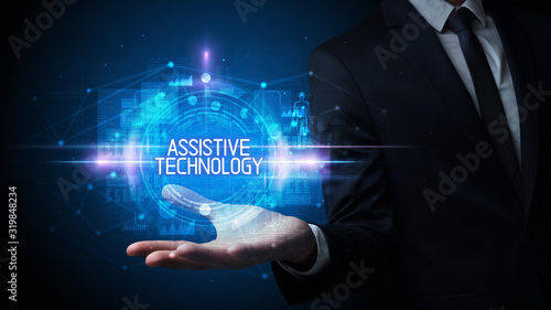 Wallpaper Mural Man hand holding ASSISTIVE TECHNOLOGY inscription, technology concept Torontodigital.ca