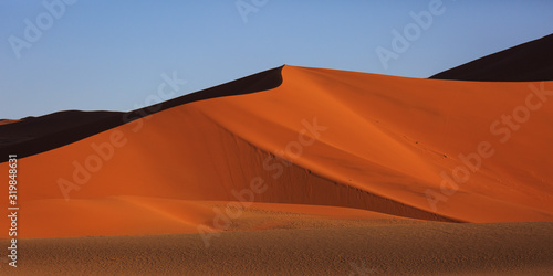 Fototapeta Naklejka Na Ścianę i Meble -  Beautiful landscape with red huge sand dunes at sunset in desert. Sossusvlei, Namib Naukluft National Park, Namibia. Stunning natural geometry without people
