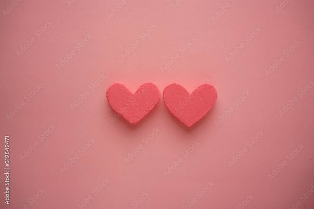Two pink hearts on a pink background. Copy space background