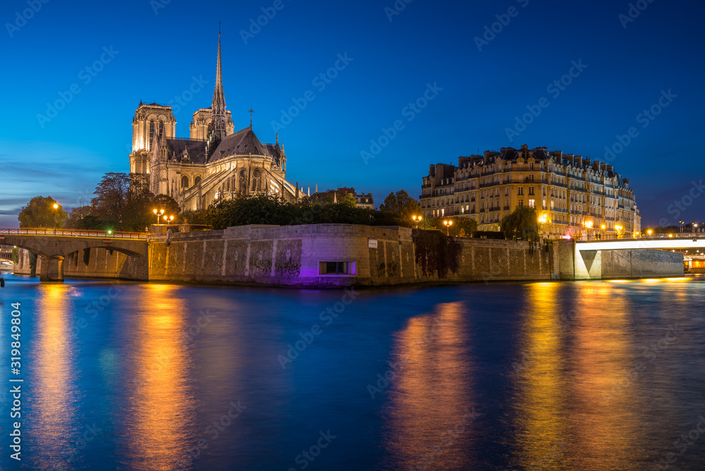 Obraz premium Church of Notre Dame de Paris in France before burning fire at sunset on river Seine reflecting lights