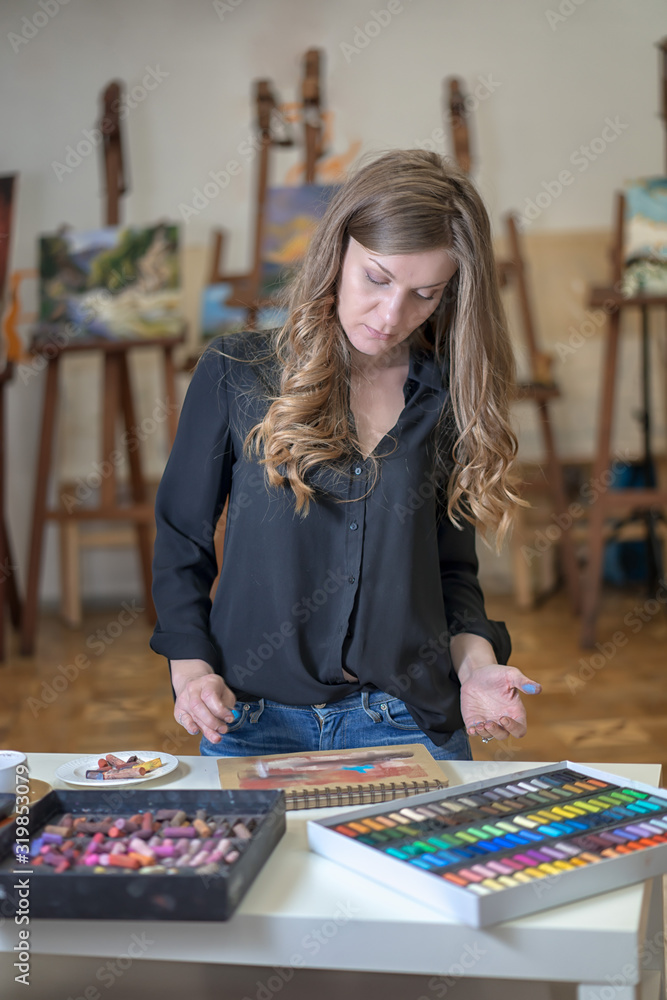 Fototapeta premium Portrait of a woman artist crayon painting in the art studio.