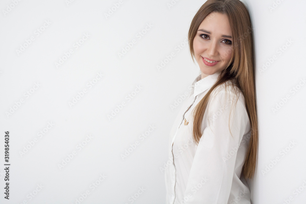 Portrait of a young beautiful happy girl, with long hair, in a white blouse, on a white background, with copy space. Concept feminine hygiene or businesswoman. Portrait of a young beautiful happy girl, with long hair, in a white blouse, on a white background, with copy space. Concept feminine hygiene or businesswoman.
