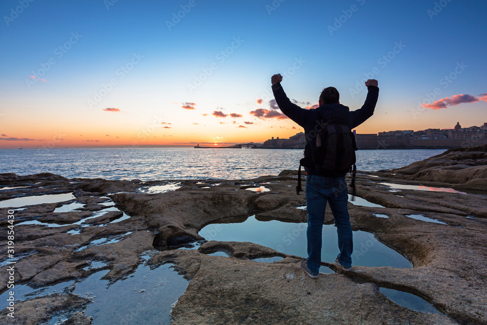 Man is watching beautiful sunrise on Malta island