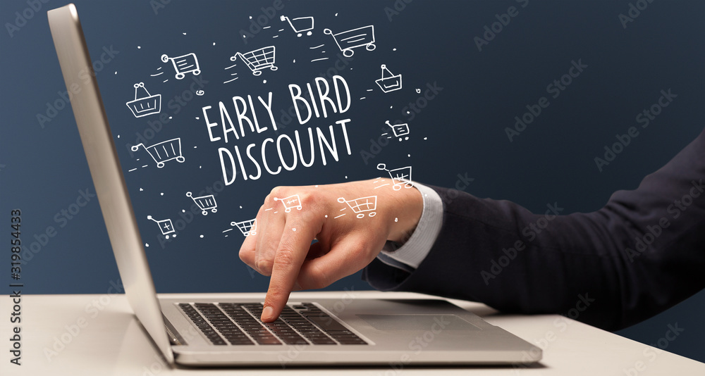 Businessman working on laptop with EARLY BIRD DISCOUNT inscription, online shopping concept Businessman working on laptop with EARLY BIRD DISCOUNT inscription, online shopping concept