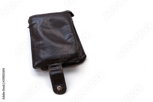 An old, worn, scratched and torn wallet made of genuine brown leather. The wallet is isolated on a white background. Poverty and need Concept. Copy space.